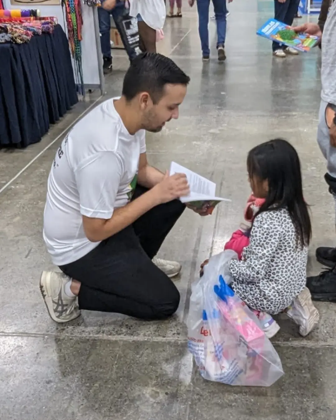 Angel Escamilla platicando con una niña emprendedora sobre Fábulas Financieras en la Feria Internacional del Libro Monterrey